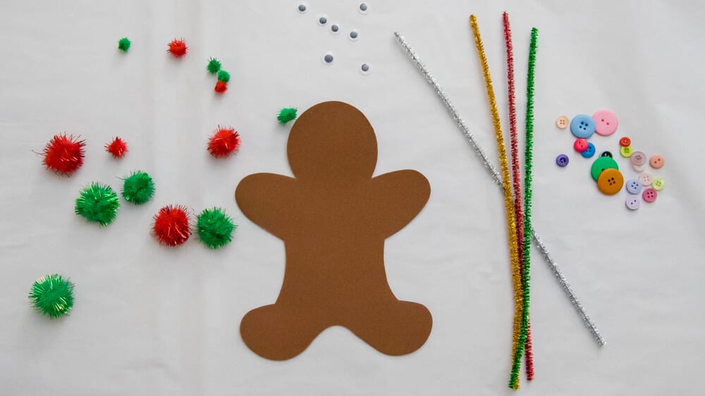 Christmas craft supplies including foam gingerbread man, pipe cleaners, pom poms, buttons, and googly eyes