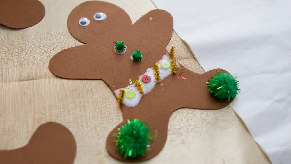 Gingerbread man craft for kids in progress with Christmas craft supplies from the dollar store